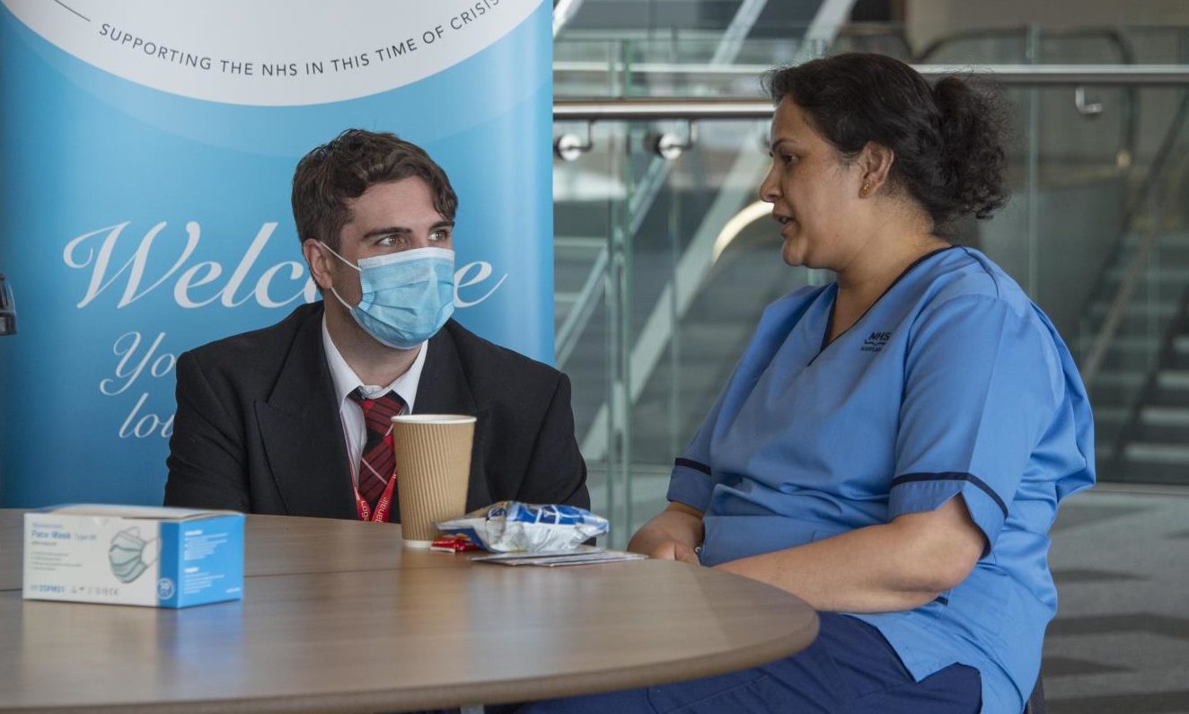 Project Wingman volunteer and cabin crew member Richard O'Toole chats to vaccinator Chaitra Prakash at P&J Live.