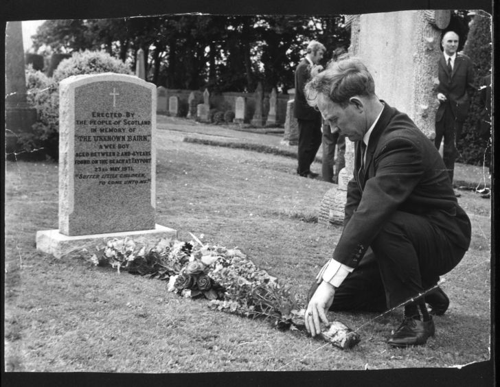 Ian Robertson places flowers on the grave in 1971.