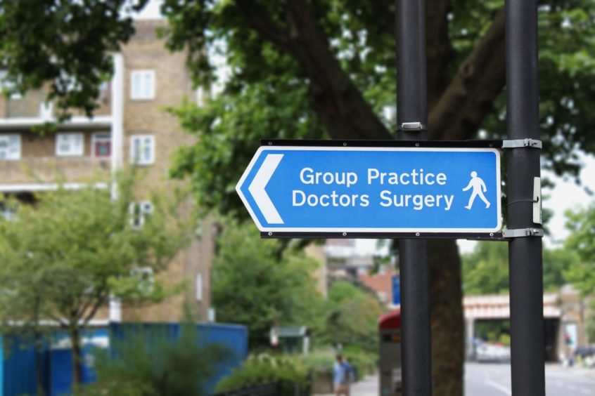 A blue sign pointing the way to a GP surgery