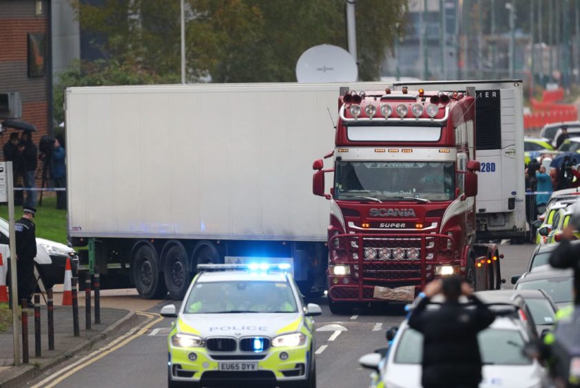 The container lorry in which 39 people were found dead inside as is it driven away by police from Waterglade Industrial Park in Grays, Essex. 