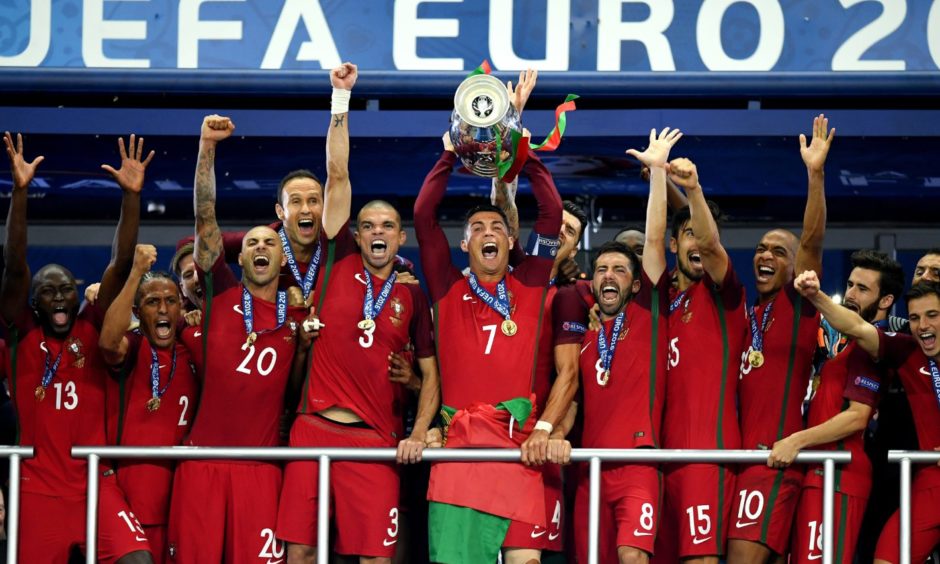 Cristiano Ronaldo of Portugal, centre, lifts the Henri Delaunay trophy after his side defeated France 1-0 in the final of Euro 2016.