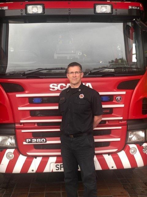 Stephen Wood, SFRS local senior officer for Dundee, Angus and Perth and Kinross standing next to a fire engine.