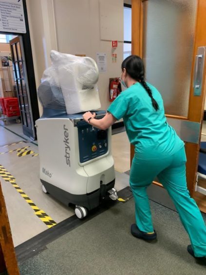 A member of staff prepares the robot for use.