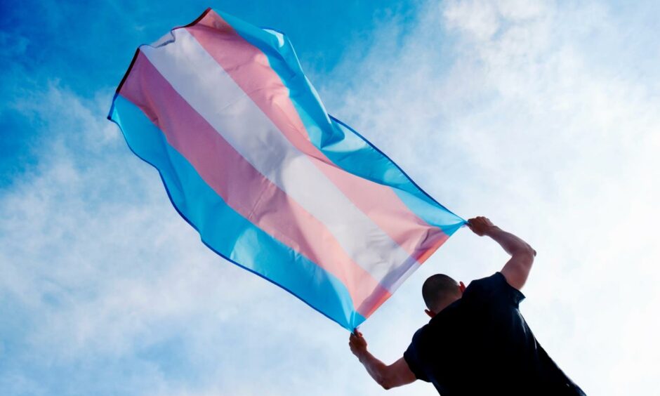 A man holding a red, white and blue striped flag