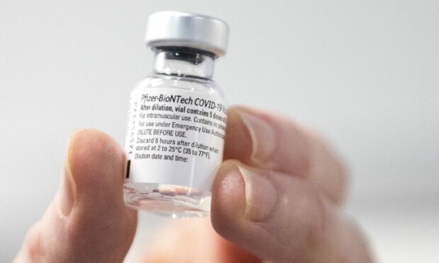 A nurse holds a bottle of Pfizer coronavirus vaccine. Some children over 12 are to be offered the jab.