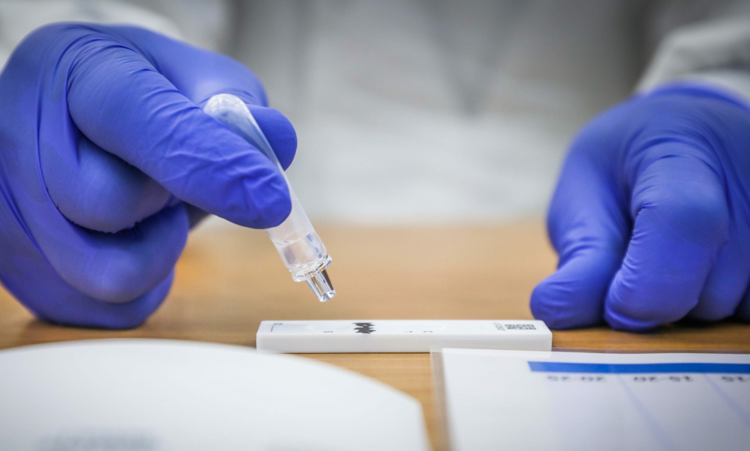 a lab technician working on a rapid lateral flow covid test