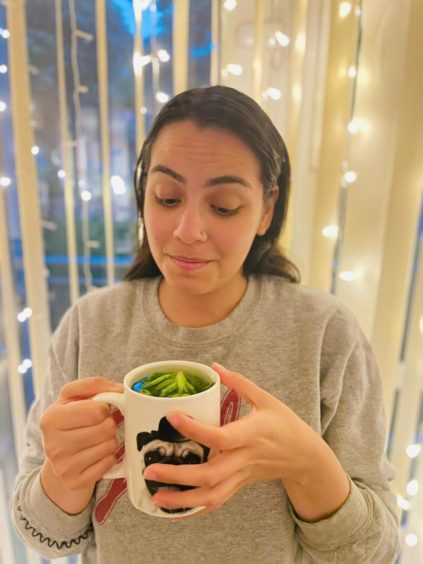 Journalist Ana holding a mug of lettuce tea