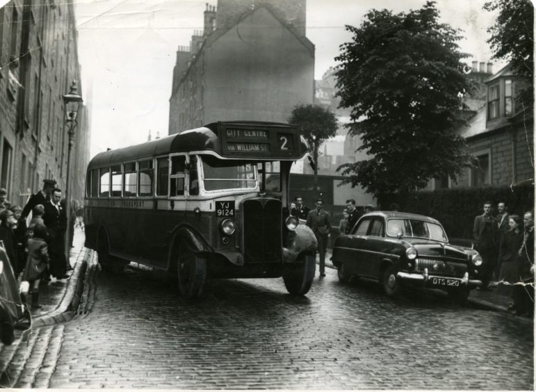 The number 2 bus heading to the City Centre can be seen making its way through a busy street in June 1954