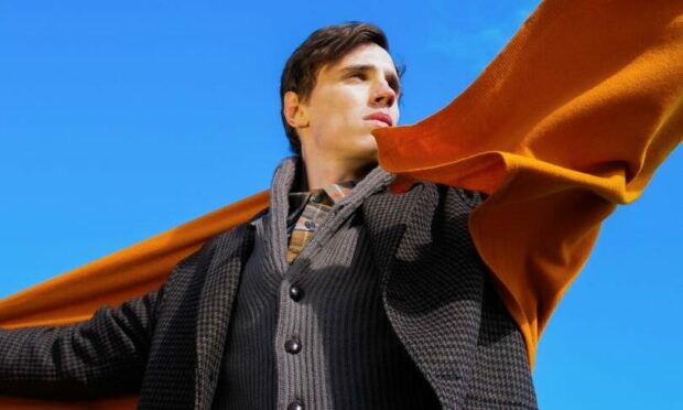 A large orange scarf from the Todd & Duncan Collection worn by a male model.