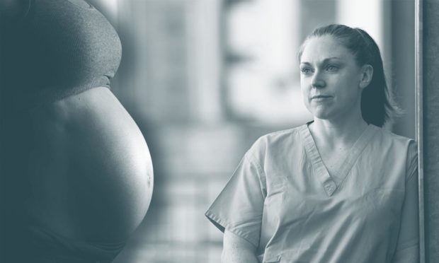 A pregnant woman's torso next to a nurse.