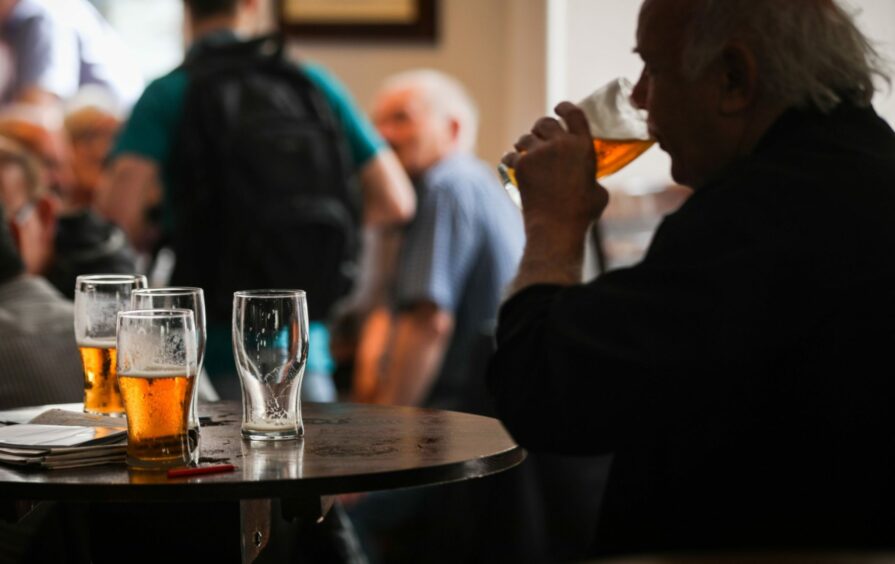 A man drinking beer in a pub. 
