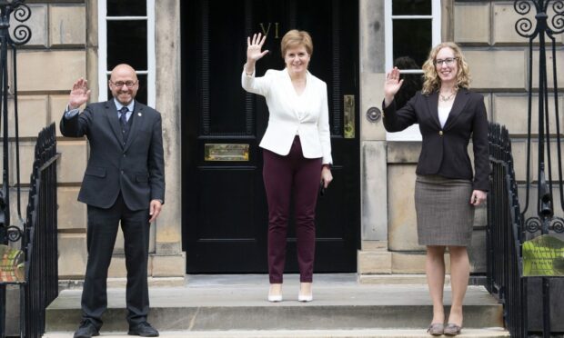 First Minister Nicola Sturgeon with Scottish Green co-leaders Patrick Harvie and Lorna Slater at Bute House in Edinburgh, waving a the camera