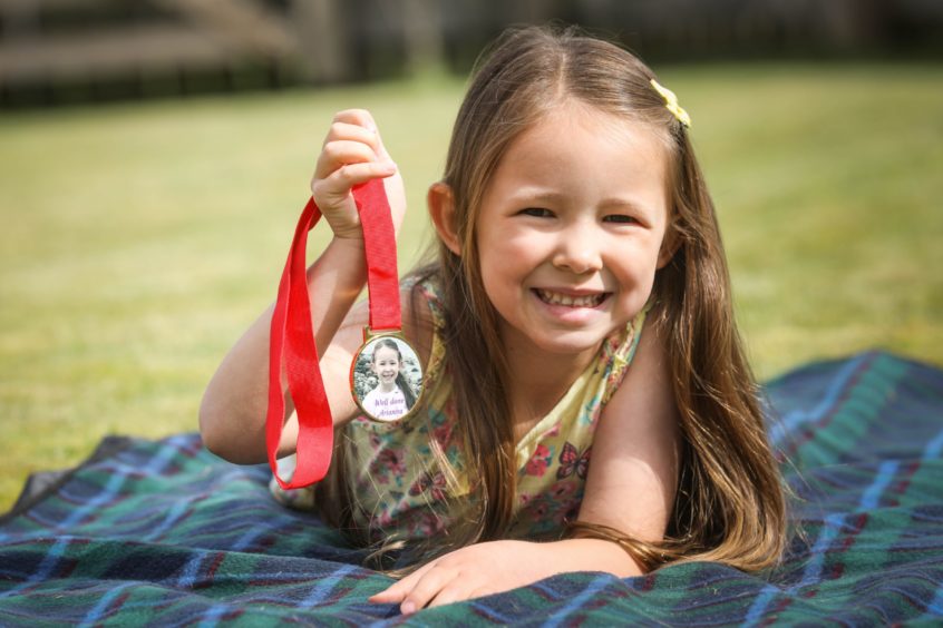 Perthshire girl Arianna showing off a medal she received for her achievements.