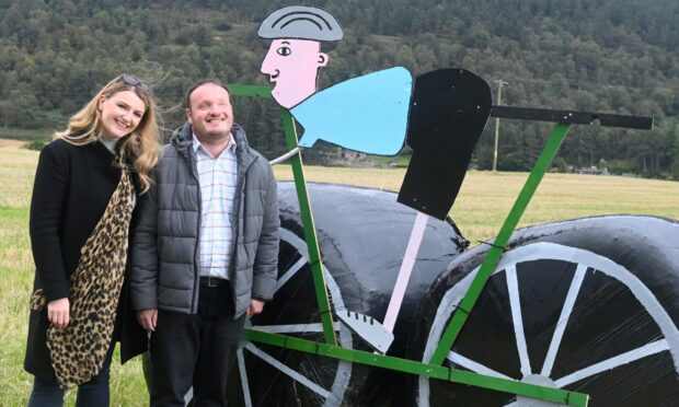 Jenna and Duncan Ross besides Tour of Britain hay bale display in Tarland