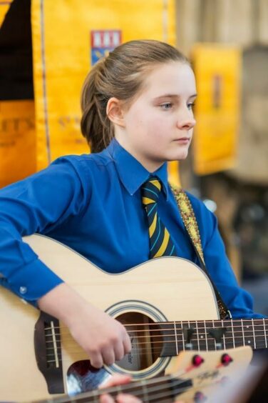  Jenna Stewart, an Aberdeen musician who recently won BBC Young Composer of the year, playing guitar.