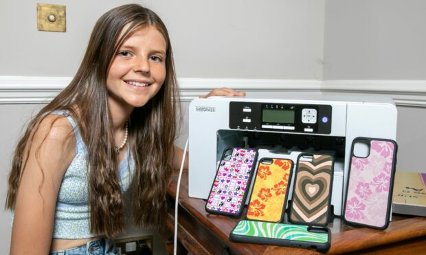 Freya Tyson with her printer and a range of colourful iPhone cases from Justencaseit.