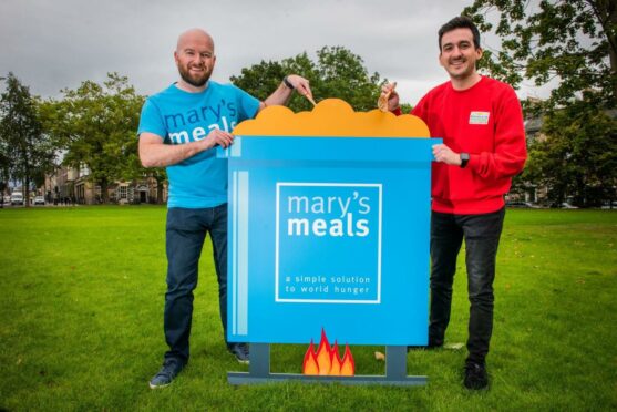 Two men from the charity and the lottery celebrate the Mary's Meals donation