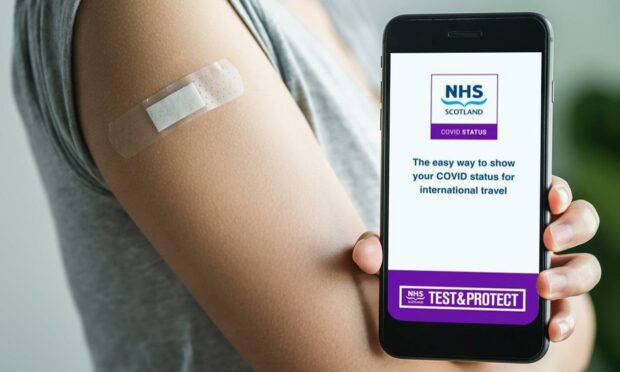 A person holding a smartphone with the new covid vaccine passport app for Scotland