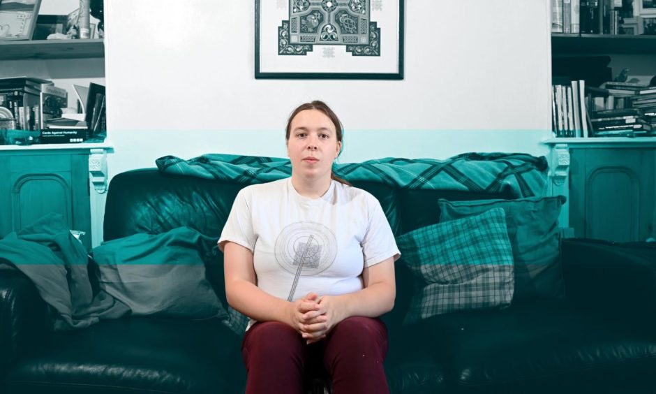 Saoirse McIntee sitting on her sofa in her flat which has been beset by mould problems
