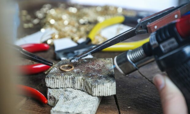 Close-up of soldering a piece of Paper People jewellery.