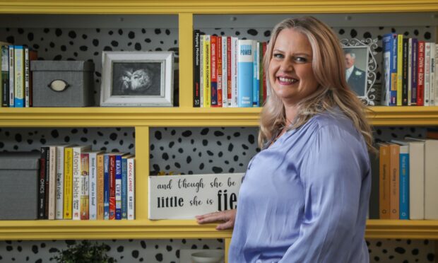 Jane Rennie from the Extraordinary Training Company in front of her bookshelf at home.