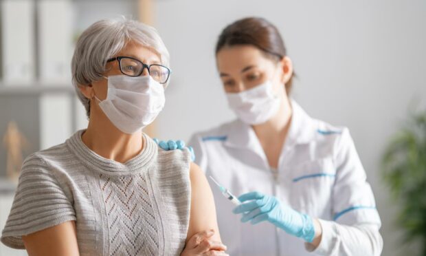 Woman getting injection from nurse.