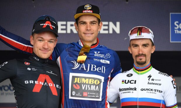 Cyclist Wout van Aert on the podium with two other riders after finishing first at the Aberdeen stage of the Tour of Britain in 2021