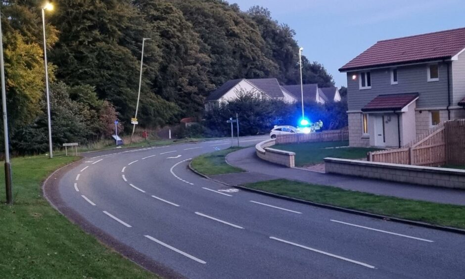 The junction of Old Glamis Road and Harestane Road, Dundee, with a crashed car and police on the scene.