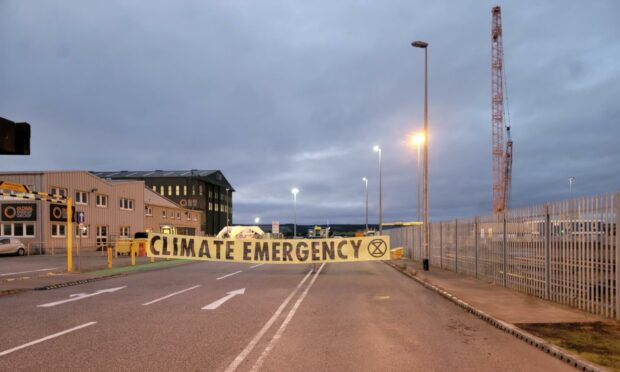 Extinction rebellion sign blockading access to Highland oil rig maintenance facility.