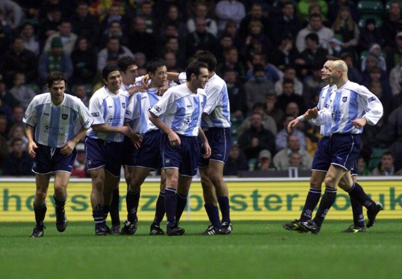 Fan Zhiyi, fourth from left, is mobbed after netting for Dundee against Celtic.