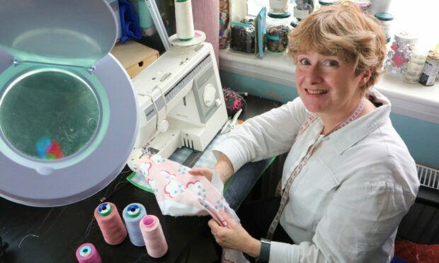 Liz Laing of Dilly Dream in front of her sewing machine.