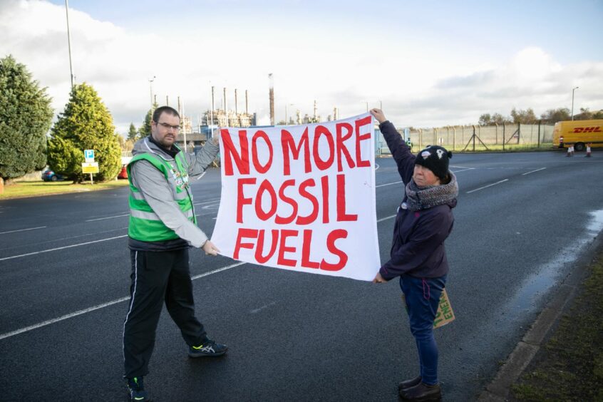 Bryce Goodall and Jemma Kettlewell from Actions Speak Louder Than Words holding a sign saying 'No more fossil fuels'