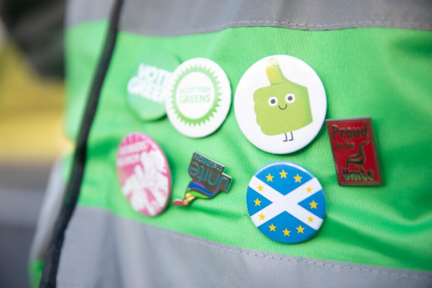 Bryce Goodall's badges including 'Scottish Greens', 'Vote Green' and 'Proud to be Unite'