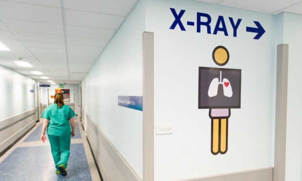 A hospital worker walks down a corridor