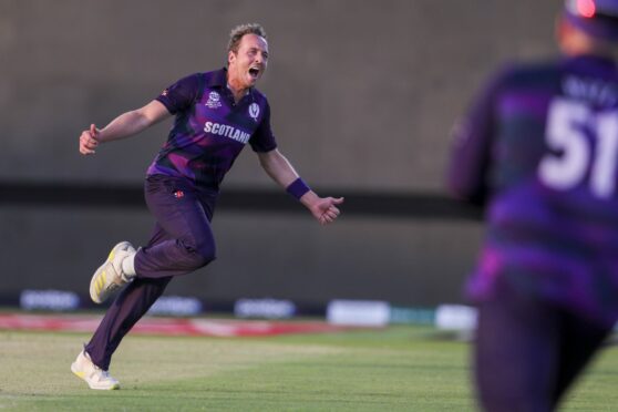 Scotland's Josh Davey celebrates after taking the wicket of Papua New Guinea's Norman Vanua.