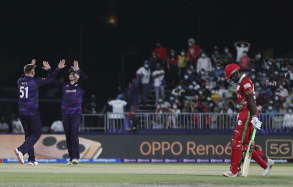 Scotland bowler Mark Watt celebrates after dismissing Oman batter Mohammad Nadeem.