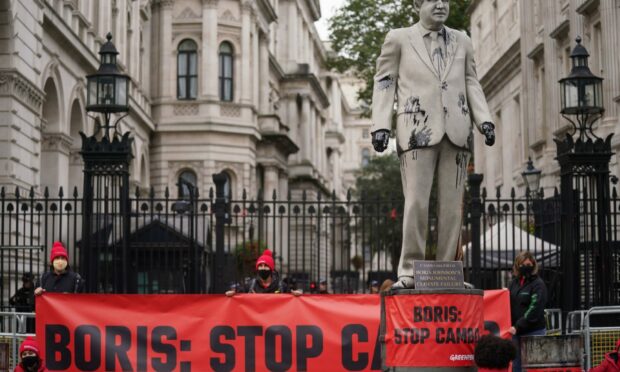 A statue of Prime Minister Boris Johnson splattered with oil as campaigners from Greenpeace demonstrate Downing Street, London, against the Cambo oil field off the west coast of Shetland.