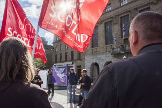 Dundee University workers holding flags during a strike rally in City Square.