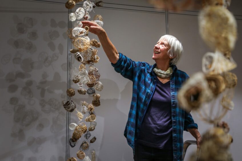 Leslie hangs her panels for the Jute and Fruit exhibition.