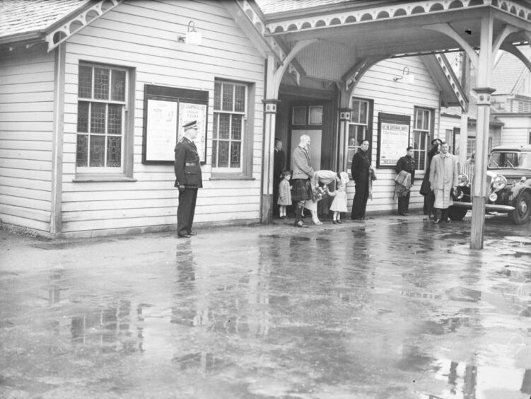 A black and white image of The Queen, Prince Charles and Princess Anne at Ballater Station