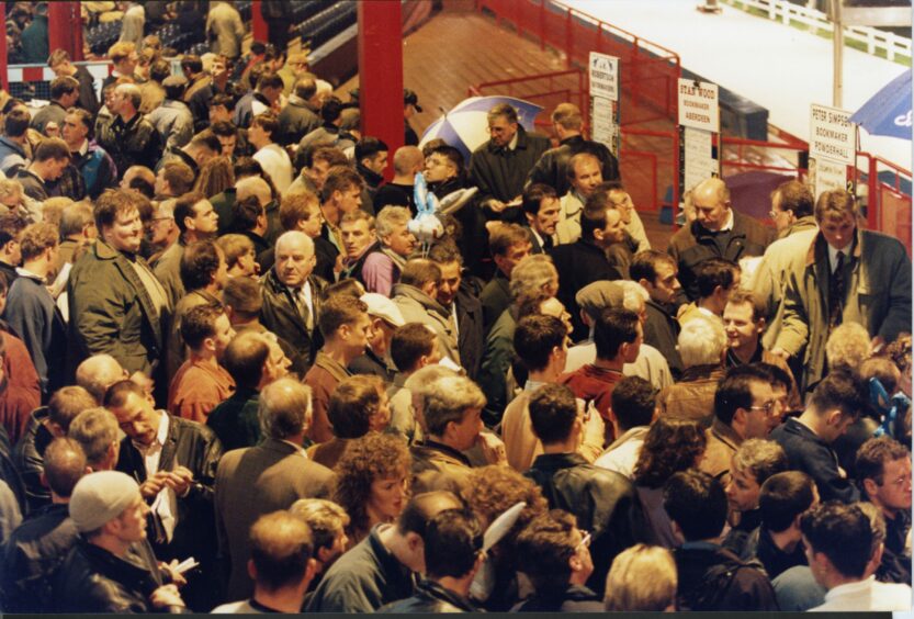 Crowds gather round the bookies' pitches on the returning night of greyhound racing at Dens Park on October 21 1994.