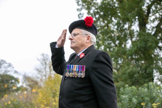 Major (retd) Colin Gray takes the salute at a Remembrance Day service at Ninewells community garden.