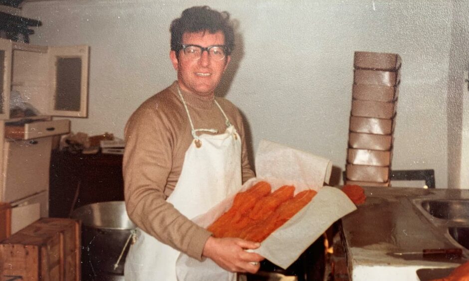 A younger dark haired Dennis Beattie pictured holding a tray of fish captured during his early days in business.