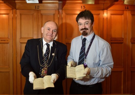 Lord Provost Barney Crockett and Senior Archivist Ruaraidh Wishart holding the Aberdeenshire soldier's diaries