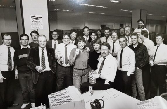 Press and Journal newsroom pictured in black and white, the day Bert left for a new job. He is shown sitting on the desk, centre.
