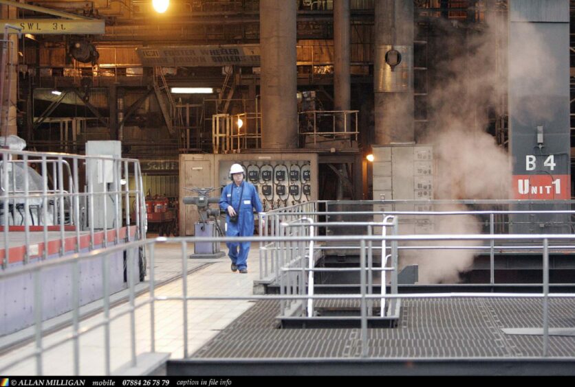 A worker on a metal gantry at the power station.