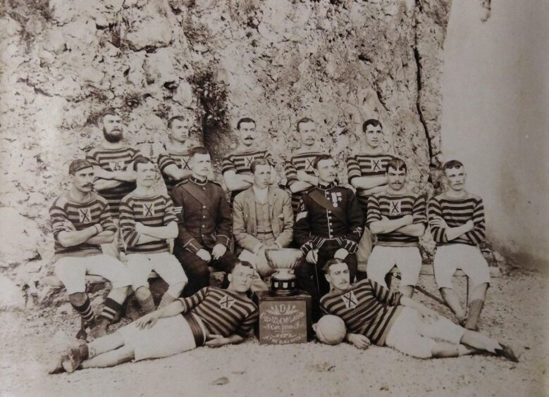 The 2nd Black Watch side that won the Army Challenge Cup and the Belfast Charity Cup. The team lined up beside a trophy.