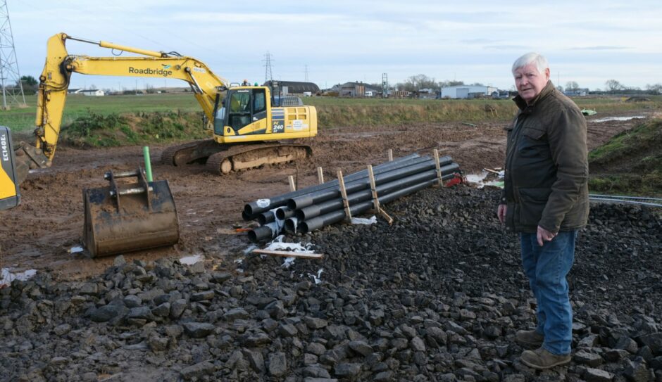 Gordon Beattie at the site with a digger and pipes in the background.