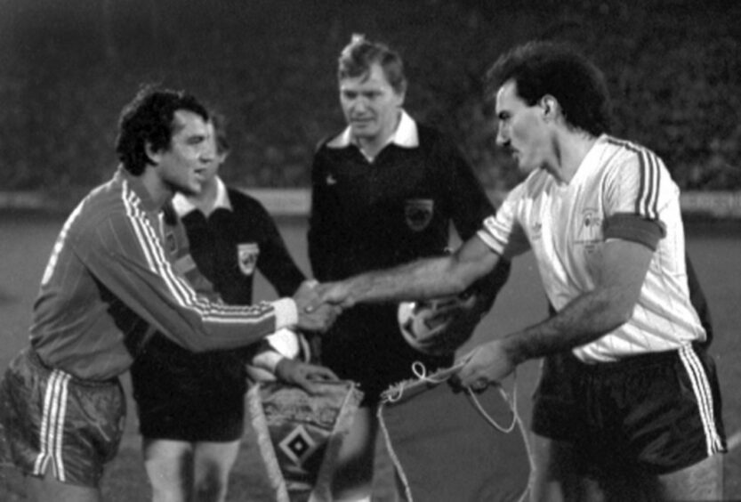 The respective captains exchange pennants before the start of the second leg at Pittodrie.