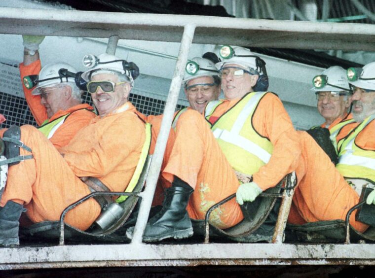  The then-Scottish Secretary of State, Donald Dewar, and others in helmet and hi-vis gear at the plant.